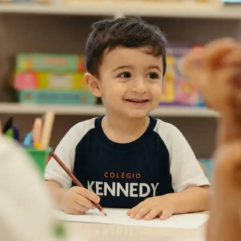 Criança da Educação Infantil do Colégio Kennedy sorrindo em sala de aula